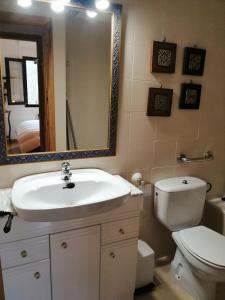 a bathroom with a sink and a toilet and a mirror at Apartamento con chimenea y vistas Falcó 10 in Pla de l'Ermita