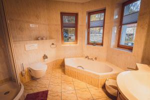 a bathroom with a tub and a toilet and a sink at Ferienwohnungen Adam Ries in Annaberg Buchholz in Annaberg-Buchholz +23 photos