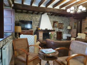 a living room with a couch and a fireplace at Posada San Tirso in Toñanes