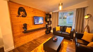 uma sala de estar com um sofá e uma TV em Spacious sheffield lodge em Sheffield