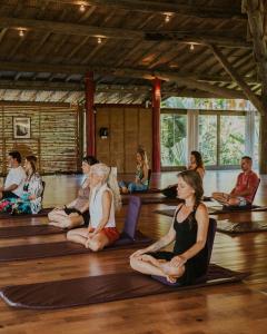 a group of people sitting in a yoga class at Pousada Mevlana Garden in Barra de Ibiraquera