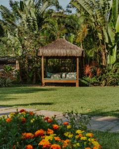 a gazebo in the middle of a lawn with flowers at Pousada Mevlana Garden in Barra de Ibiraquera +96 photos