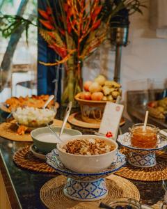 a buffet with bowls of food on a table at Pousada Mevlana Garden in Barra de Ibiraquera