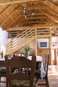 a dining room with a table and chairs and a tv at Faluszéli Vendégház - Boncz Porta in Nagyrákos