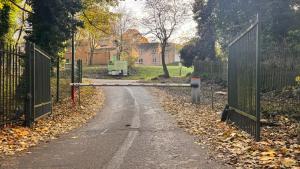 um portão em uma estrada com folhas no chão em Spacious sheffield lodge em Sheffield