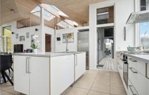 eine Küche mit weißen Schränken und einer Holzdecke in der Unterkunft Gorgeous Home In Hvide Sande With Sauna in Bjerregård