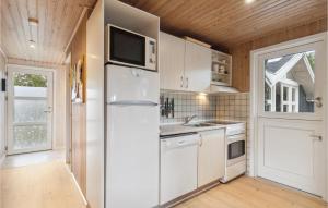 a kitchen with white appliances and a refrigerator at Holiday Home Musvågevej I in Ålbæk