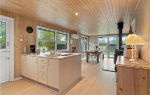 a kitchen with wooden walls and a wooden ceiling at Holiday Home Musvågevej I in Ålbæk +18 photos