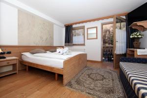 a bedroom with a large bed and a window at Aparthotel Wellness Villa di Bosco in Tesero