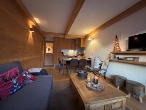 a living room with a couch and a table at La tanière des Chamois 7p - proche piste Chalvet in Montgenèvre