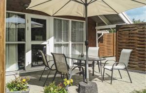 a table and chairs with an umbrella on a patio at Holiday Home Blomstervangen Ka Denm in Oksbøl