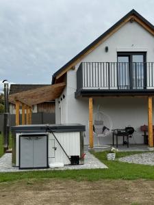 a white house with a patio and a grill at Stodoła in Brenna
