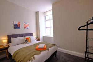 a bedroom with a bed with an orange towel on it at Large 2-3 Bed FREE Parking, En-suite in Harrogate