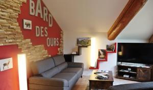 a living room with a couch and a flat screen tv at Gîte BARD des OURS in Saint-Martin-en-Vercors