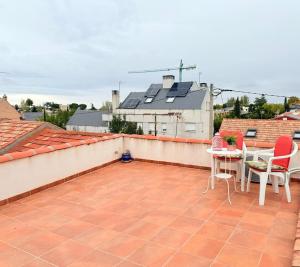 a patio with a table and chairs on a roof at Rosa House, Chalet 4 habitaciones y 4 baños in Pozuelo de Alarcón