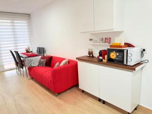 a living room with a red couch and a table at Rosa House, Chalet 4 habitaciones y 4 baños in Pozuelo de Alarcón
