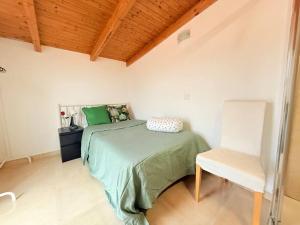 a bedroom with a green bed and a white chair at Rosa House, Chalet 4 habitaciones y 4 baños in Pozuelo de Alarcón