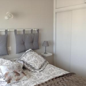 Dormitorio con cama con almohada y lámpara en Le Trebens centre ville à 150m du télécabine, en Font-Romeu