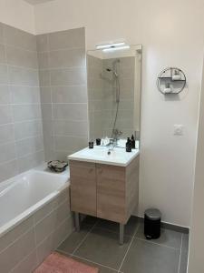 a bathroom with a sink and a tub and a mirror at Charmant appartement a Bormes les Mimosas in Bormes-les-Mimosas