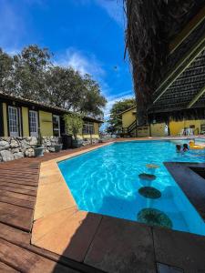 a swimming pool with blue water in front of a building at Pousada Pontal da Praia in São Pedro da Aldeia