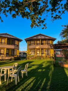 a building with chairs and a table in front of it at Pousada Pontal da Praia in São Pedro da Aldeia