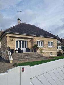 a brick house with a white fence in front of it at A la casa de papel in Neuilly-sous-Clermont