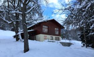 een rood-wit huis in de sneeuw bij Le Green Chalet in Villard-sur-Boëge