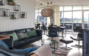 Una sala de estar con un sofá, mesas y sillas. en Four-Bedroom Holiday Home In Ringkobing, en Ringkøbing