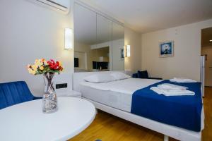 a bedroom with a bed and a vase of flowers on a table at Your great stay in Batumi in Batumi