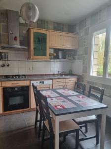 a kitchen with a table with chairs and a sink at A la casa de papel in Neuilly-sous-Clermont