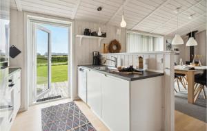a kitchen with white cabinets and a large window at Holiday Home Sydals With Hot Tub Vii in Sarup