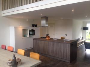 a kitchen with a wooden island and a counter top at Suite School 15 A in Zonnemaire