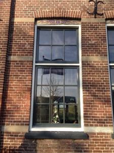 a window of a brick building with a christmas tree at Suite School 15 A in Zonnemaire