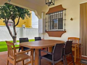 a table and chairs in a patio with a tree at Casa Los Henke - Ole Solutions in El Puerto de Santa María