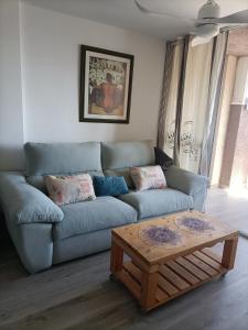 un salon avec un canapé bleu et une table basse dans l'établissement Alminares Playa 3 dormitorios, à Aguadulce