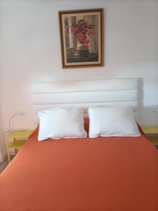 - un lit avec deux oreillers et une photo sur le mur dans l'établissement Alminares Playa 3 dormitorios, à Aguadulce