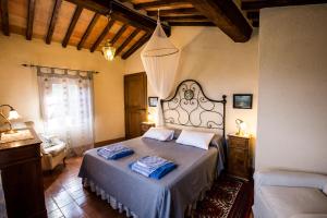 1 dormitorio con 1 cama y 1 silla en una habitación en Agriturismo Castelrotto, en Palazzone
