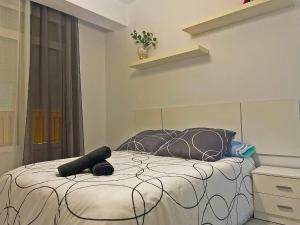 ein Schlafzimmer mit einem Bett mit einer schwarz-weißen Bettdecke in der Unterkunft La Torre de la Catedral - Ole Solutions in Jerez de la Frontera