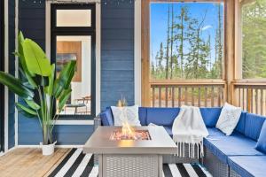 a blue couch on a porch with a fire pit at Celestial Cottage with HotTub, Cold Plunge,Games in Dwight
