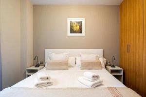 a bedroom with a bed with towels on it at Moderno apartamento con vistas al mar en Valencia in Valencia