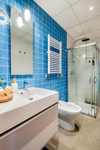 a bathroom with a sink and a toilet and blue tiles at Moderno apartamento con vistas al mar en Valencia in Valencia