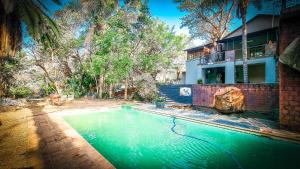 a swimming pool in front of a house at Montrose River Lodge in Schoemanskloof