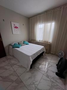 a bedroom with a large bed with a window at Piscina, lazer e diversão em Cabo Frio in Cabo Frio +11 photos