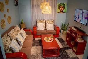 ein Wohnzimmer mit Sofa und Tisch in der Unterkunft ILBORU HAVEN HOMEs in Arusha