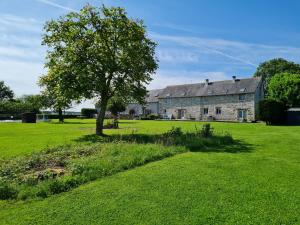 an old stone house with a tree in a field at La Maison Neuve Gîtes in Madré