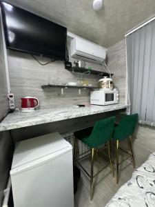 - une petite cuisine avec un comptoir et 2 chaises vertes dans l'établissement Cozy good apartment, à Chişinău 8 autres photos
