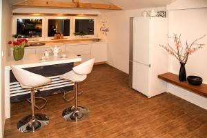a kitchen with a refrigerator and a table and chairs at Angel's Nest Apartment in Komenda +31 photos