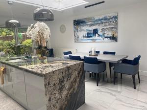 a dining room with a table and blue chairs at Beautiful 3 Bedroom Home in St Albans in Saint Albans