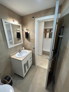 a bathroom with a sink and a mirror at Apartamento acogedor en primera línea de playa in La Pineda