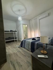 ein Schlafzimmer mit einem Bett und einem Tisch mit einer Lampe in der Unterkunft Solemar2 in Giardina Gallotti
